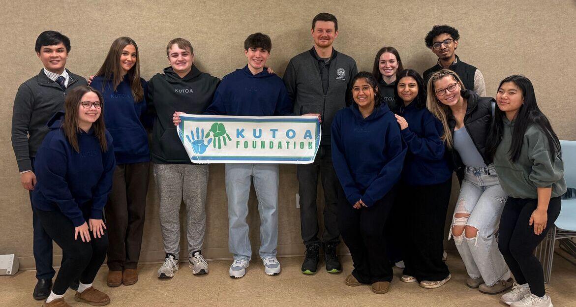 Kutoa Advocacy Program members gathered with a Kutoa Foundation banner